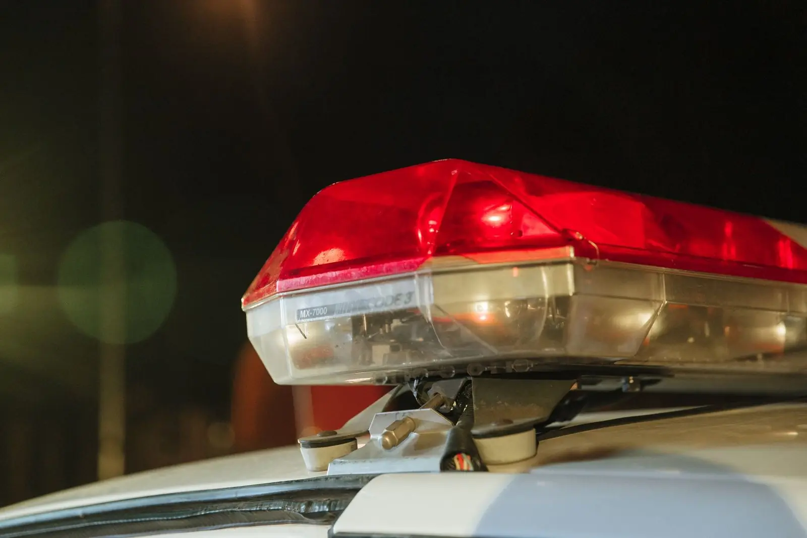 Red emergency light on the roof of a patrol car at night