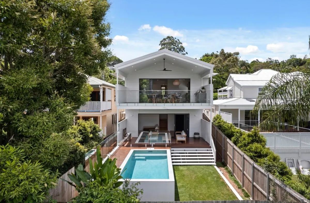 Modern white Queensland home with a backyard pool in bright sunshine