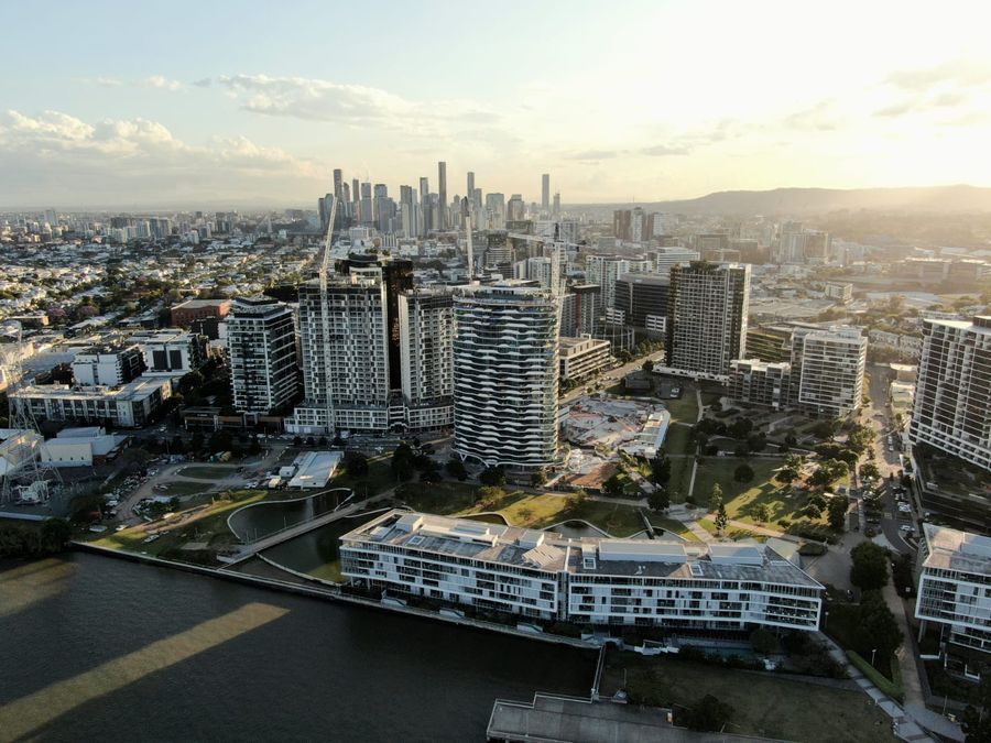 Aerial view of Brisbane riverside apartments and city skyline at golden hour
