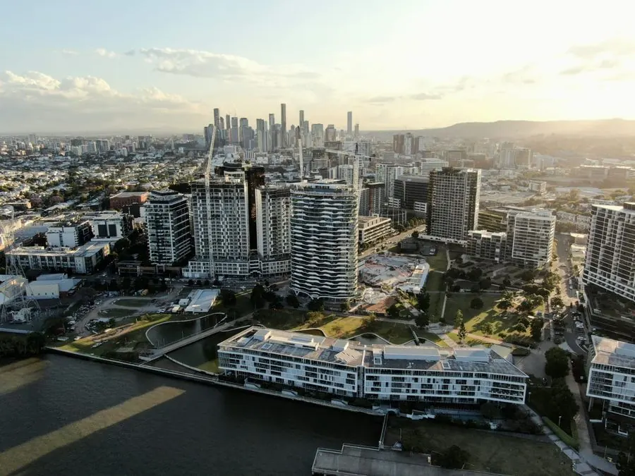 Aerial view of Brisbane riverside apartments and city skyline at golden hour